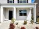 View of front porch on two story home with well-manicured landscaping at 5088 Wavering Place Loop, Myrtle Beach, SC 29579