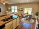 Open-concept kitchen features an island with a sink and a view of the dining area and living room at 5088 Wavering Place Loop, Myrtle Beach, SC 29579