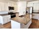 Modern kitchen with granite countertops, stainless steel appliances, and island sink at 5088 Wavering Place Loop, Myrtle Beach, SC 29579