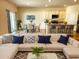 Living room with white sectional, decor pillows and open view to the dining room and kitchen bar at 5088 Wavering Place Loop, Myrtle Beach, SC 29579