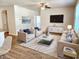 Open living room with fan, lots of light, contemporary furniture, a large screen tv, and decor at 5088 Wavering Place Loop, Myrtle Beach, SC 29579