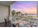 Balcony with views of palm trees, pool area, and a picturesque beach at sunset at 5300 N Ocean Blvd. # 217, Myrtle Beach, SC 29577