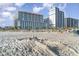 Sunny beach day featuring sandcastle, white sand, blue skies and resort in background at 5300 N Ocean Blvd. # 217, Myrtle Beach, SC 29577