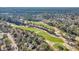 An aerial view showcasing a lush green golf course lined with mature trees at 100 Deloach Trail, Pawleys Island, SC 29585