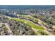 An aerial view showcases a home overlooking a lush green golf course with mature trees surrounding the community at 100 Deloach Trail, Pawleys Island, SC 29585