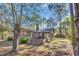 Brick home with a sunroom addition overlooks an expansive backyard with mature trees at 100 Deloach Trail, Pawleys Island, SC 29585