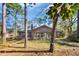 Brick home with a sunroom addition overlooks an expansive backyard with mature trees at 100 Deloach Trail, Pawleys Island, SC 29585