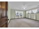 Bedroom featuring three windows with white curtains, light green walls, ceiling fan, and carpeted flooring at 100 Deloach Trail, Pawleys Island, SC 29585