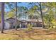 Traditional home features a brick facade, attached garage, and lush landscaping enhancing its serene setting at 100 Deloach Trail, Pawleys Island, SC 29585