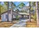 Charming brick home featuring a long driveway framed by mature trees, offering privacy and curb appeal at 100 Deloach Trail, Pawleys Island, SC 29585