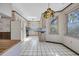 Bright kitchen with white appliances and cabinets, black and white tile floor, and a colorful hanging light at 100 Deloach Trail, Pawleys Island, SC 29585