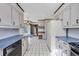 Spacious kitchen with white cabinets, black appliances, and a black and white tiled floor at 100 Deloach Trail, Pawleys Island, SC 29585