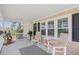 Inviting front porch with rocking chairs, a patterned rug, and a view of the front yard at 107 Ben Horry Trail, Pawleys Island, SC 29585