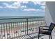 A balcony view overlooking the beach and ocean with many people and umbrellas on the beach at 107 S Ocean Blvd. # 704, Myrtle Beach, SC 29577