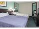 Bright bedroom featuring two beds, modern decor, and a full-length mirror at 107 S Ocean Blvd. # 704, Myrtle Beach, SC 29577
