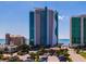 Condo complex exterior showcasing the building's design and proximity to the ocean, blue sky and parking at 107 S Ocean Blvd. # 704, Myrtle Beach, SC 29577