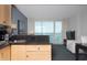 A kitchenette with stainless steel sink, faucet, countertop and cabinets adjacent to a living room area with ocean views at 107 S Ocean Blvd. # 704, Myrtle Beach, SC 29577
