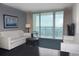 Living room in condo with ocean view, white couch, and sliding glass doors leading to a balcony at 107 S Ocean Blvd. # 704, Myrtle Beach, SC 29577