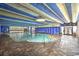 Relaxing indoor swimming pool area featuring large windows, cozy lighting, and comfortable lounging at 1105 South Ocean Blvd. # 208, Myrtle Beach, SC 29577