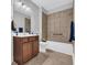 Cozy bathroom featuring a tub with tiled shower, tile floor, and wooden vanity at 1309 Suncrest Dr., Myrtle Beach, SC 29577