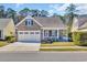 Charming home featuring a stone facade, a well-manicured lawn, and an attached two-car garage at 1309 Suncrest Dr., Myrtle Beach, SC 29577