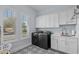 Modern laundry room with front load washer and dryer and ample cabinet space at 1549 Casita Ln., Myrtle Beach, SC 29579
