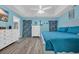 Bright main bedroom boasts blue walls, white furniture, wood-look floors, a tray ceiling, and a large window with decorative curtains at 171 Talon Dr., Conway, SC 29527