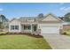 Inviting single-Gathering home showcasing manicured lawn, neutral siding, blue shutters, and a convenient attached garage at 198 Ford Rd., Pawleys Island, SC 29585