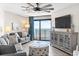 Comfortable living room featuring a large TV, stylish decor, and access to a balcony with ocean view at 201 74Th Ave. N # 1802, Myrtle Beach, SC 29572