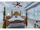 A view of the primary bedroom with a four-poster bed, tray ceiling, and ceiling fan at 2180 Waterview Dr. # 513, North Myrtle Beach, SC 29582