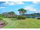 Lush green lawn with mature palm trees and meticulous landscaping creates an inviting atmosphere in this waterfront condo community at 2180 Waterview Dr. # 513, North Myrtle Beach, SC 29582