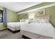 Bright bedroom featuring two beds with white linens and tropical themed art at 2301 S Ocean Blvd. # 1023, Myrtle Beach, SC 29577
