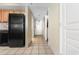 Tiled hallway leading to front door and kitchen with a large black refrigerator and cabinets at 2301 S Ocean Blvd. # 1023, Myrtle Beach, SC 29577