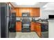 Modern kitchen featuring black appliances, wood cabinets, and a tile floor at 2600 N Ocean Blvd. # 1914, Myrtle Beach, SC 29577