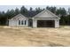 Charming single-story home with gray siding and a spacious two-car garage, set against a backdrop of lush trees at 2921 Hughes Gasque Rd., Aynor, SC 29511