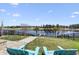 Serene backyard view with waterfront access, dock, Adirondack chairs, and lush landscaping on a sunny day at 296 West Palms Dr., Myrtle Beach, SC 29579