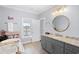 Bright bathroom featuring granite counters, a soaking tub with tile surround, and large window providing natural light at 296 West Palms Dr., Myrtle Beach, SC 29579