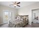 Comfortable bedroom with balcony access, ceiling fan, wood floors, and a decorative comforter, creating a cozy retreat at 296 West Palms Dr., Myrtle Beach, SC 29579