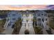 Beautiful waterfront home with dual elevated balconies, lush landscaping, and serene sunset backdrop at 296 West Palms Dr., Myrtle Beach, SC 29579