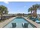 Backyard pool area with lounge chairs, palm trees, and a distant golf course view at 296 West Palms Dr., Myrtle Beach, SC 29579