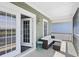 A covered porch featuring comfortable seating with a woven couch and a small side table at 296 West Palms Dr., Myrtle Beach, SC 29579