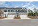 Modern townhomes featuring stone accents, garages, and a well-maintained street at 300 Golan Circle # A, Myrtle Beach, SC 29579
