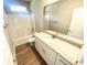 Bright bathroom featuring a combination tub and shower, along with a stylish granite countertop vanity at 311 St. Andrews Ln., Myrtle Beach, SC 29588