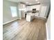 An open view of a kitchen with white cabinets, stainless steel appliances, granite counters, and hardwood floors at 311 St. Andrews Ln., Myrtle Beach, SC 29588