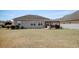 Backyard with grass, gray siding and a patio with table, chairs, and grill at 321 Galway Ct., Longs, SC 29568
