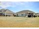 Backyard with grass, gray siding, white fence, and a patio with table, chairs, and grill at 321 Galway Ct., Longs, SC 29568