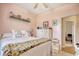 Cozy bedroom with light pink walls and shelf decor over a white bed and bright accents at 321 Galway Ct., Longs, SC 29568