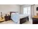 Bedroom with wood frame bed with blue striped bedding, window, and bedside tables at 321 Galway Ct., Longs, SC 29568