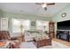 Inviting living room with a comfortable couch, ceiling fan, fireplace, and natural light from the windows at 321 Galway Ct., Longs, SC 29568