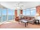 Inviting living room with ocean views, ceiling fan, balcony access, and comfortable sofa at 3500 N Ocean Blvd. # 902, North Myrtle Beach, SC 29582